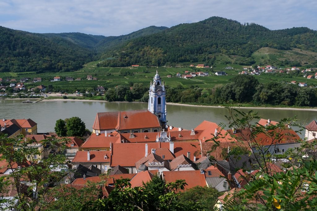 Widok z austriackiego miasteczka na jezioro i góry po jego drugiej stronie, letni, spokojny krajobraz