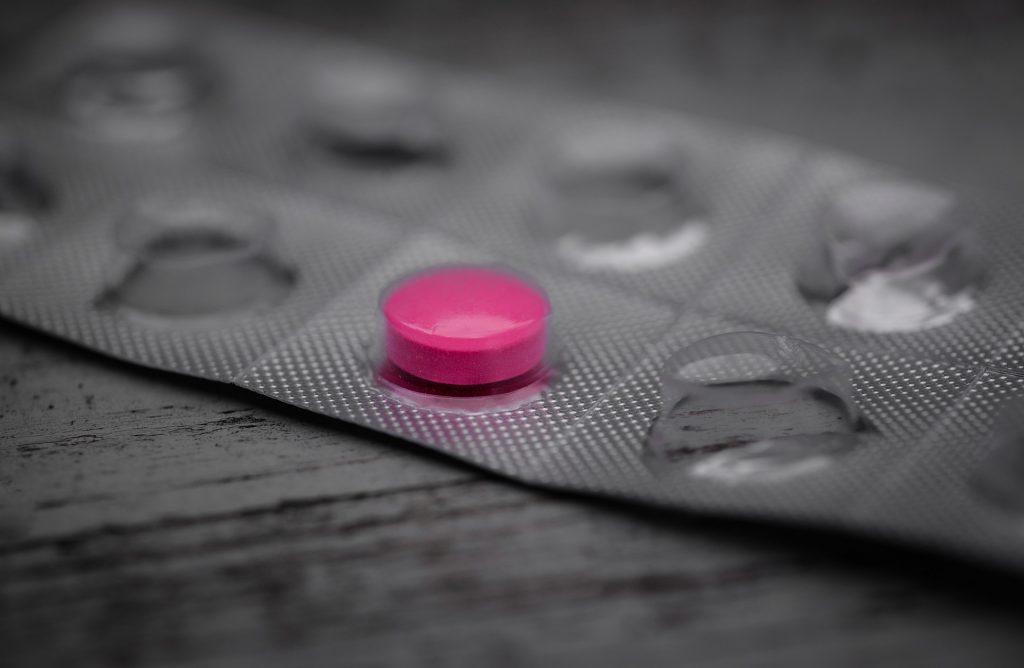 Jedna tabletka o kolorze różowym w pustym blistrze po lekach