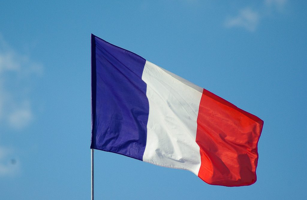 Powiewająca na tle niebieskiego nieba francuska flaga