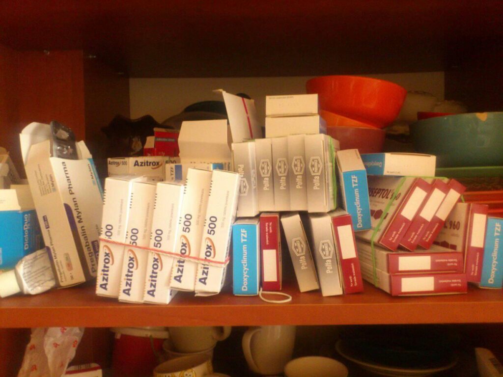 wiele różnych pudełek z antybiotykami, luźno ułożonych na półce
