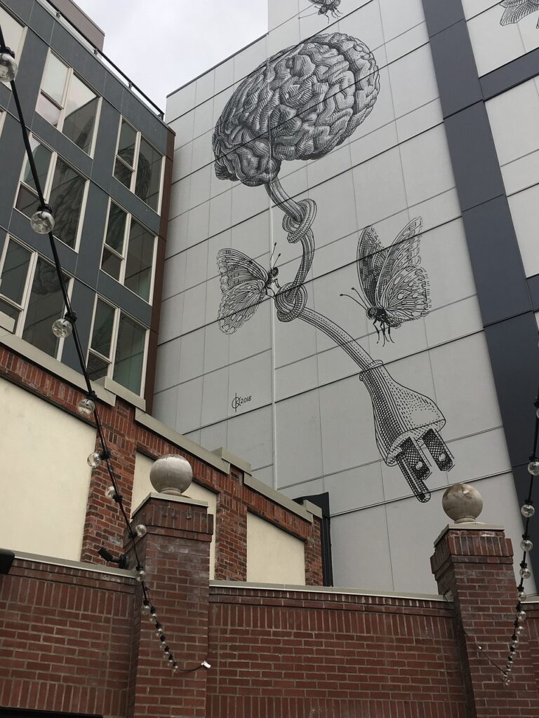 Grafiti na ścianie pokazujące mózg z nerwem błędnym przedstawionym jako kabel z wielką wtyczką